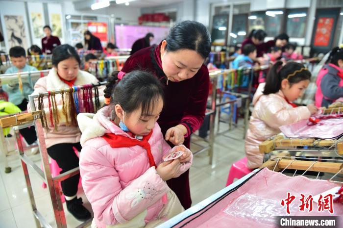 江西省級非遺豫章繡傳承人手把手指導小學生繡制2022年北京冬奧會吉祥物“冰墩墩”形象?！∮髟屏?攝