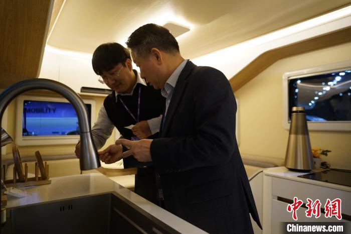 圖為參展商向觀眾介紹房車內(nèi)部設(shè)計(jì)?！⑿?攝