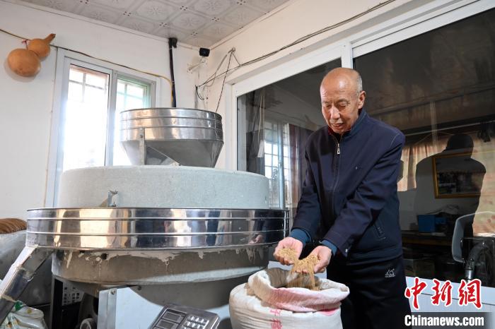 李家莊村民谷文朝重拾父輩的手藝，做起石磨面粉的營生?！〉杂鸺?攝