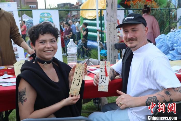 當(dāng)?shù)孛癖娫跐h字體驗工作坊展示自己手寫的中文名書簽?！◆斻肟鬃訉W(xué)院供圖