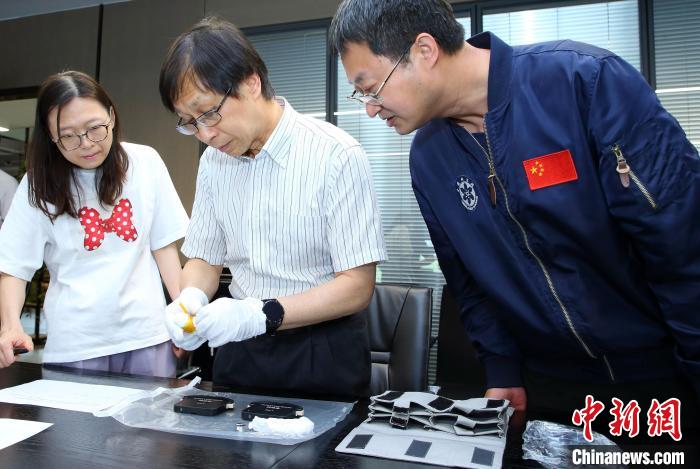 科研人員查看隨神舟十五號返回地面的空間科學實驗樣品?！≈锌圃嚎臻g應(yīng)用中心 供圖