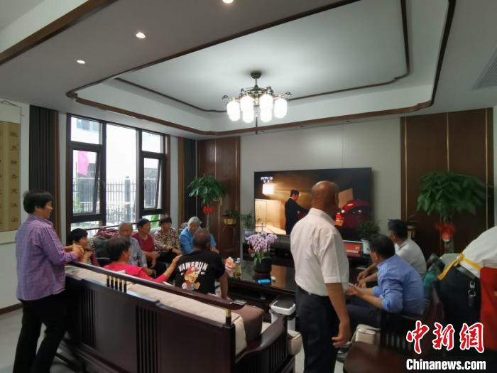 親友們集中在費(fèi)俊龍家中觀看返程的視頻。　鐘升 攝