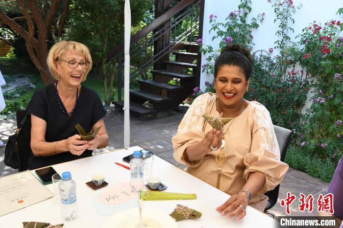 圖為嘉賓展示包粽子成果?！“亓种袊幕行墓﹫D。