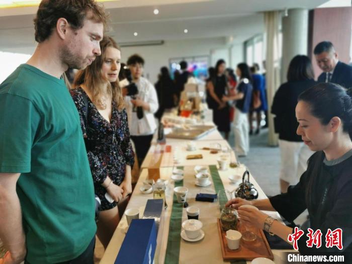 現(xiàn)場觀眾觀看中國展臺茶藝表演、了解茶文化。　靖樹 攝