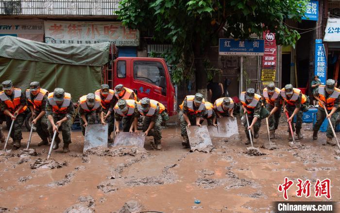 7月4日，萬(wàn)州區(qū)五橋街道，武警官兵清理街道上的淤泥?！∪矫宪?攝