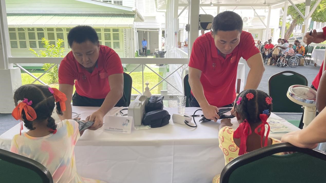 醫(yī)療隊(duì)員為福利院兒童進(jìn)行檢查。第18期援圭亞那醫(yī)療隊(duì)供圖
