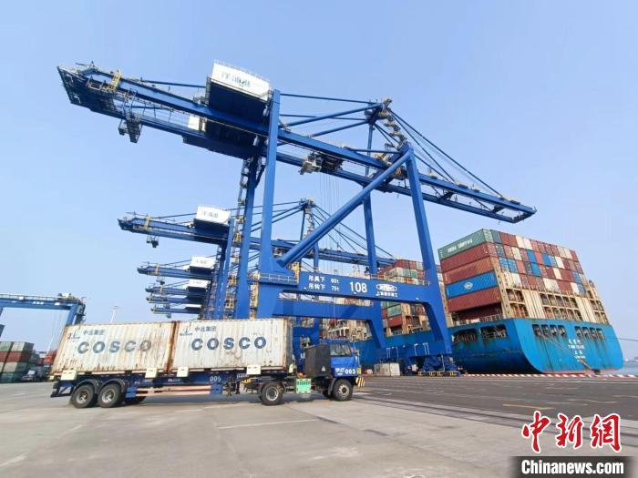 圖為海南洋浦國際集裝箱碼頭，卡車將集裝箱從后方堆場運(yùn)往碼頭裝卸區(qū)?！?jiān)潞?攝