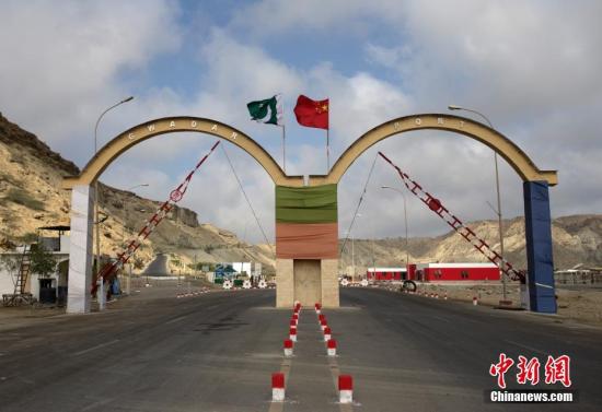 5月5日，瓜達(dá)爾港出入口的拱門(mén)。瓜達(dá)爾港是阿拉伯海沿岸的一座天然不凍良港，也是中巴經(jīng)濟(jì)走廊的南端起點(diǎn)。中國(guó)公司自2013年開(kāi)始取得瓜達(dá)爾港的運(yùn)營(yíng)權(quán)，目前各項(xiàng)工作逐步展開(kāi)。盡管自然條件差、物資匱乏，但瓜達(dá)爾卻有著重要的地理位置。瓜達(dá)爾是巴基斯坦通往波斯灣和阿拉伯海的大門(mén)，距離霍爾木茲海峽僅400公里。作為一帶一路有益補(bǔ)充的中巴經(jīng)濟(jì)走廊經(jīng)濟(jì)構(gòu)架的確立，使位于巴基斯坦最南端的瓜達(dá)爾港成為中巴經(jīng)濟(jì)走廊的一個(gè)重要出?？?。<a target='_blank' href='/'><p  align=