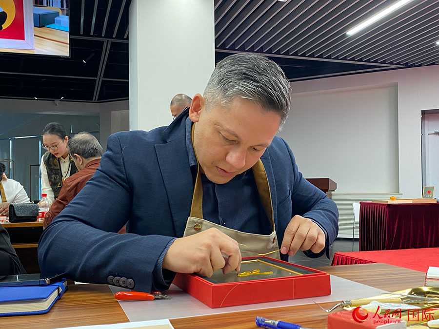 2023“一帶一路”媒體合作論壇聯(lián)合采訪團團員，親身體驗景泰藍工藝。人民網(wǎng)記者 于洋攝