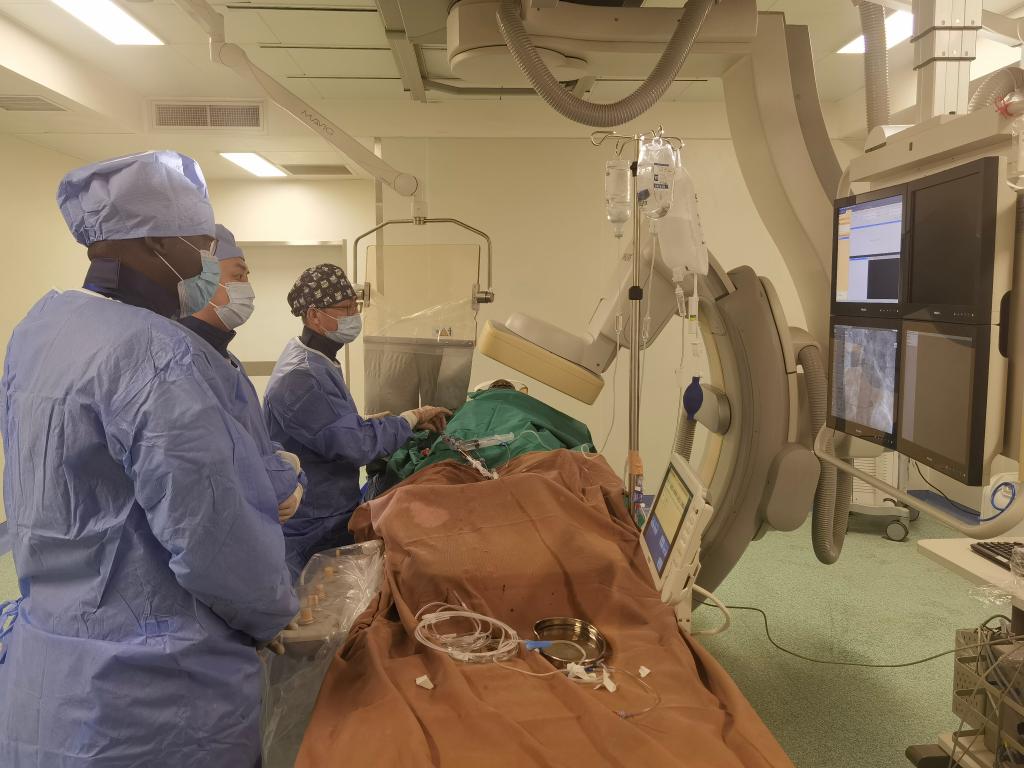 中國(guó)第29批援幾內(nèi)亞醫(yī)療隊(duì)隊(duì)員、首都醫(yī)科大學(xué)附屬北京天壇醫(yī)院心內(nèi)科副主任醫(yī)師王汝朋（右一）正在給患者做手術(shù)。（北京天壇醫(yī)院供圖）