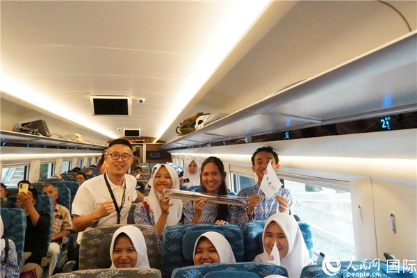 第一次乘坐雅萬高鐵動(dòng)車組的學(xué)生們與動(dòng)車組模型合影。人民網(wǎng)記者曹師韻攝