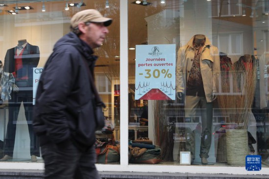   10月31日，一名男子從比利時(shí)布魯塞爾一家貼有打折信息的店鋪前走過。新華社記者 趙丁喆 攝