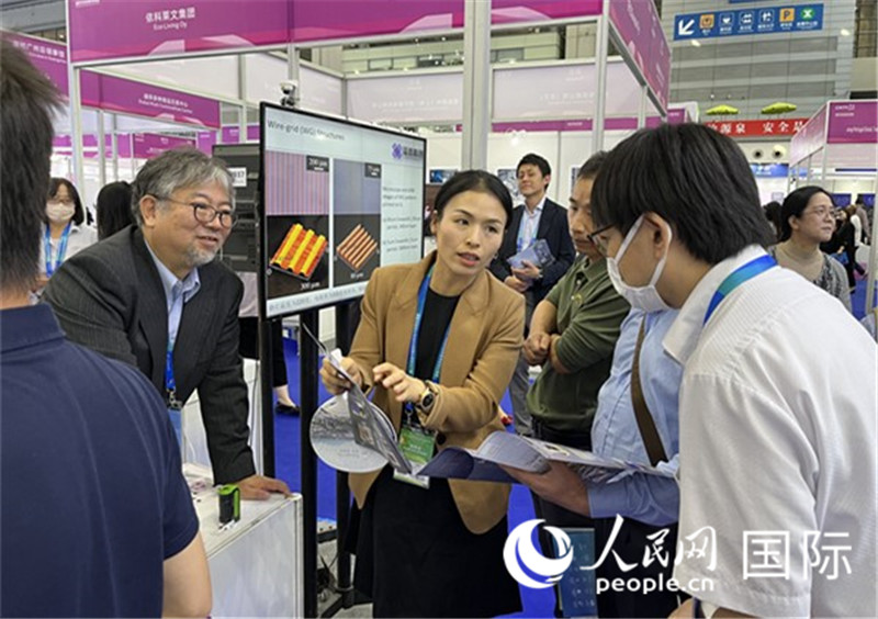 工作人員向參觀者介紹超級(jí)噴墨技術(shù)。（人民網(wǎng)記者 陳思攝）