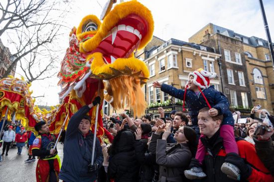 2月11日，人們在英國倫敦的新春巡游活動中觀看舞龍表演。新華社發(fā)（史蒂芬·程攝）