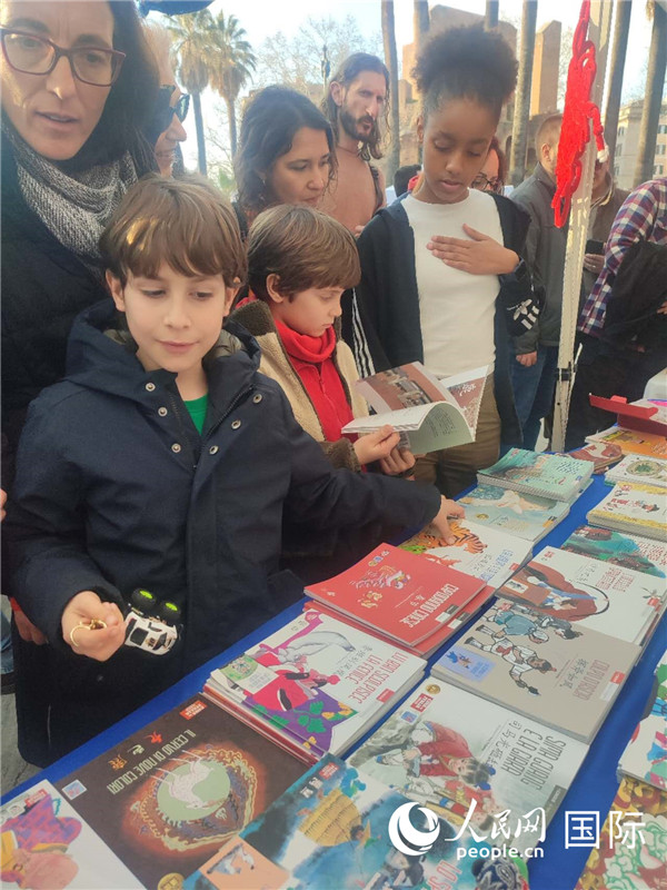 印刷精美的中國傳統(tǒng)文化叢書吸引了小游客的注意。人民網(wǎng)記者鄭彬攝