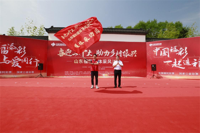 為媒體采風(fēng)團(tuán)授旗。 山東省福彩供圖