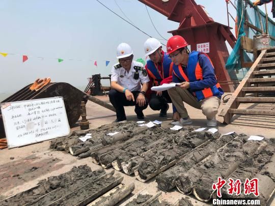 圖為勘察設(shè)計(jì)人員與海事局工作人員查看巖芯情況?！∥赫?攝