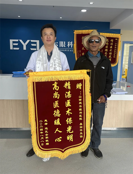 達(dá)瓦老人向吳四華（左）贈送錦旗。受訪者供圖