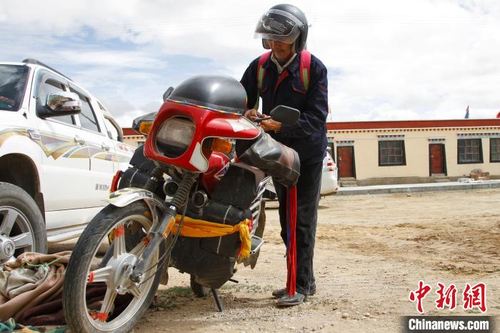 圖為白瑪準備騎摩托車巡湖。　趙朗 攝