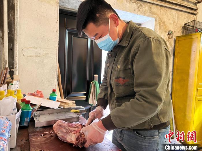 圖為雪豹“奶爸”史壽軍正在準(zhǔn)備投喂雪豹的食材?！●R銘言 攝