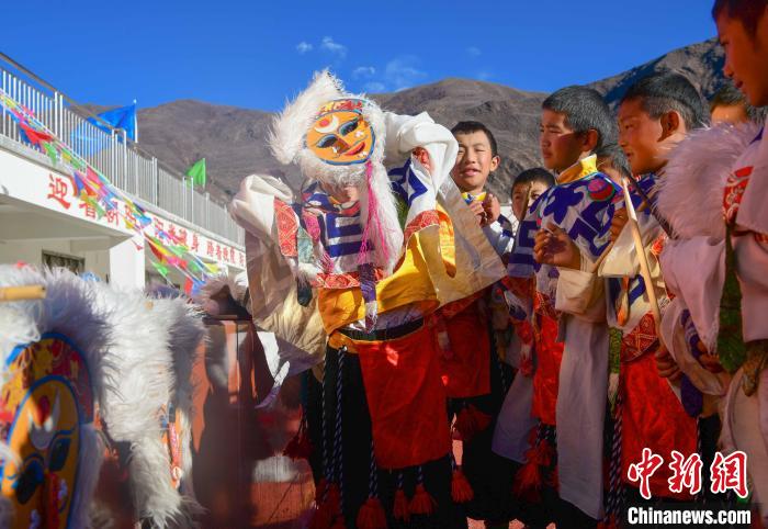 圖為加查縣安繞鎮(zhèn)小學(xué)學(xué)生在試穿藏戲面具?！∝暩聛?lái)松 攝