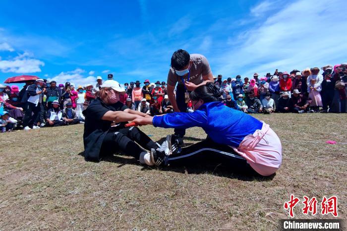 圖為當地民眾進行蹬棍比賽?！±铍h 攝