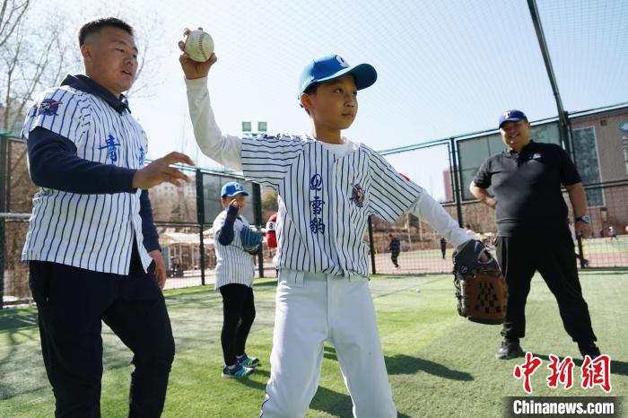 圖為教練指導(dǎo)小棒球手?jǐn)S球技術(shù)?！●R銘言 攝