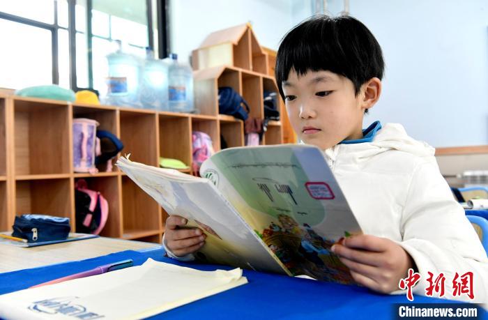 3月14日，西藏拉薩市第一小學(xué)一年級(jí)六班學(xué)生丁增樂(lè)吉在閱讀藏語(yǔ)課本?！±盍?攝