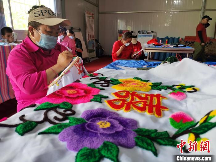 圖為婦女制作青繡?！?zhí)砀?攝