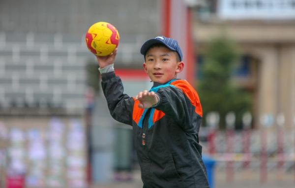在高原上教孩子們打手球，“慢慢兒來(lái)，甭著急！”