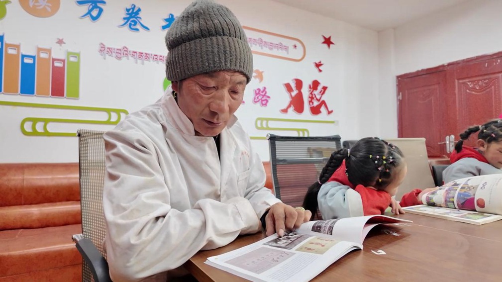 一位當(dāng)?shù)卮迕窈秃⒆觽冊谀良視堇锉M情享受閱讀時光。申扎縣融媒體中心供圖