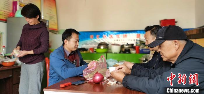 圖為扶貧路上“臨時(shí)一家人”準(zhǔn)備午餐?！∥航ㄜ?攝