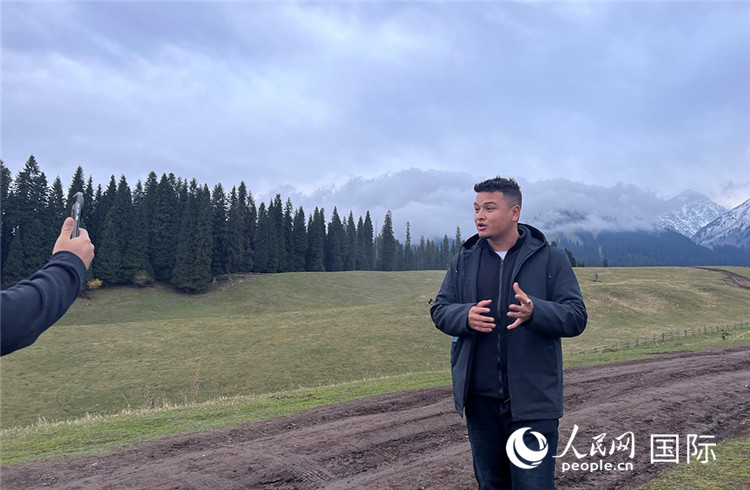 在庫(kù)爾德寧，吾買爾江被雪山美景震撼，即興錄制了短視頻作品。人民網(wǎng)記者曾書柔攝