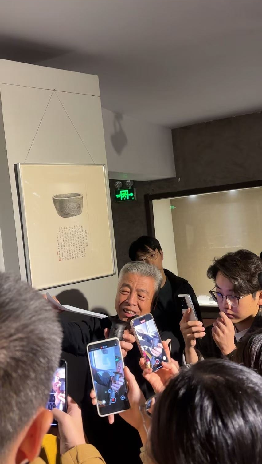 黑陶邢文化博物館館長邢葆東展示兩張相疊的A4紙，向記者解釋此為杯口的厚度。