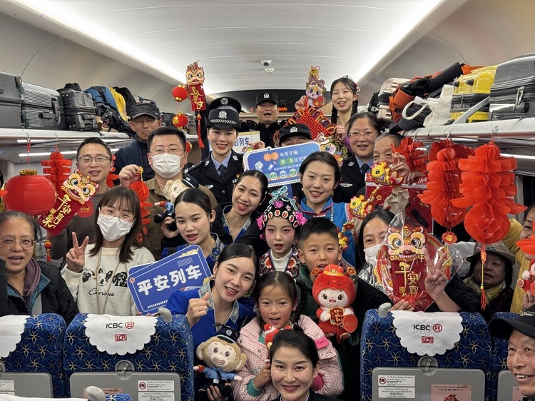 春節(jié)期間，在中老鐵路磨萬（磨丁—萬象）段，鐵路客運員工與乘客合影留念。李加勇攝