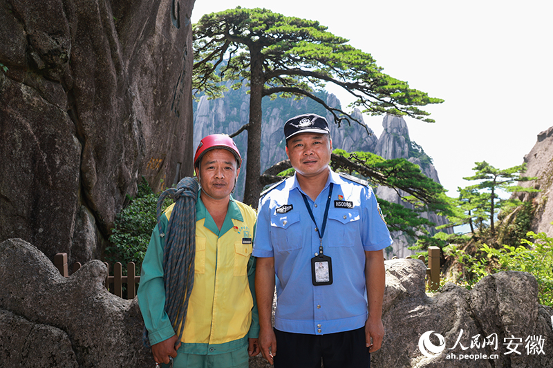 全國(guó)道德模范李培生（左）和胡曉春在迎客松前合影。人民網(wǎng)記者 張俊攝