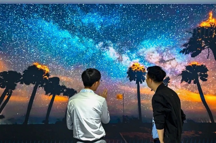 長春光博會希達(dá)電子展區(qū)，一位工作人員正在給一位觀眾講解。（長春新區(qū)供圖）