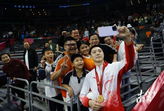 11月12日，十五運會男籃成年組決賽，廣東隊獲得冠軍后，胡明軒與球迷們合影留念。張由瓊 攝