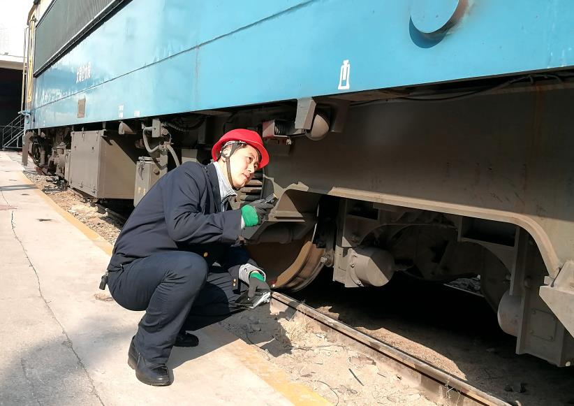 韓文盛全神貫注檢查機(jī)車(chē)走行部。