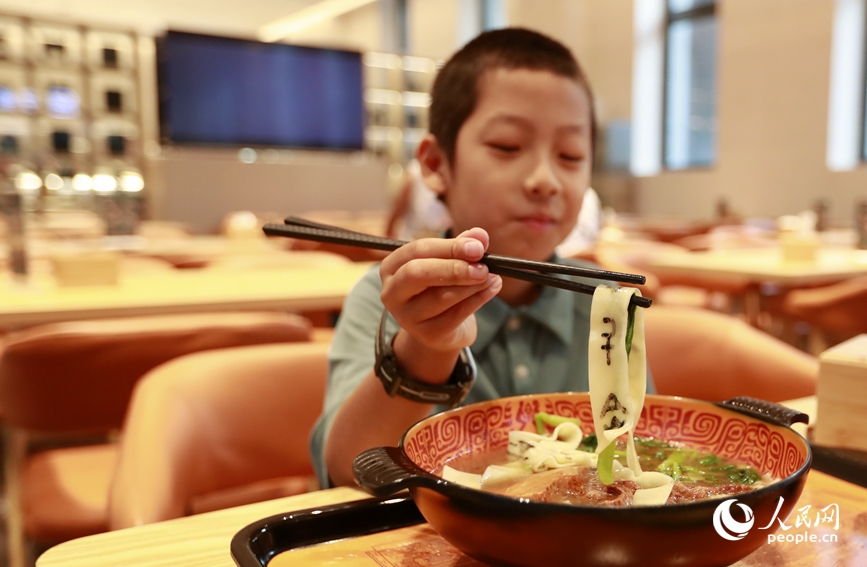 殷墟博物館推出的甲骨文面深受游客喜愛。人民網(wǎng)記者 慎志遠(yuǎn) 攝