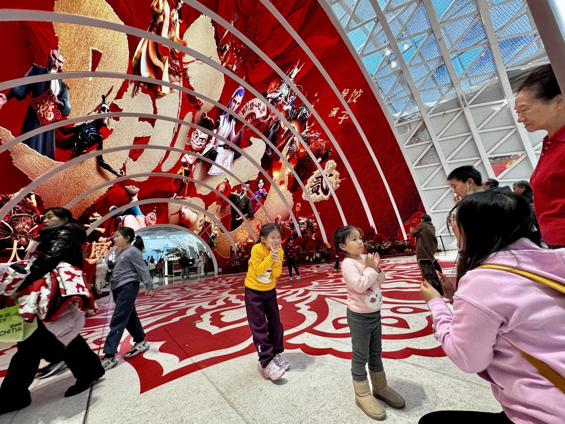 乙巳蛇年春節(jié)期間，影迷在《哪吒之魔童鬧?！肪薹?bào)前拍照打卡。