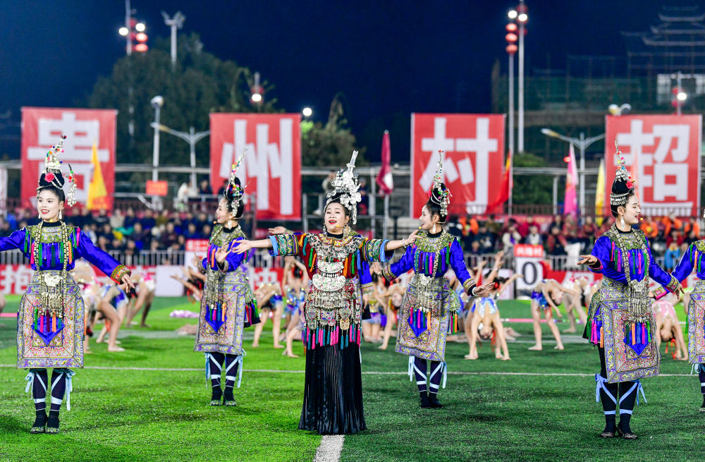 2025年3月14日，2025年貴州“村超”40強交叉賽在榕江“村超”足球場舉行，演員在比賽間隙表演侗族大歌，民族文化伴隨著體育賽事成功“出圈”。圖片來源：新華社