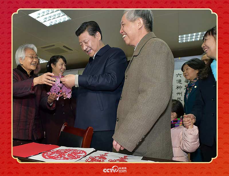 2015年2月15日，習近平在西安市雁塔區(qū)電子城街道二〇五所社區(qū)服務中心欣賞社區(qū)居民的剪紙作品。