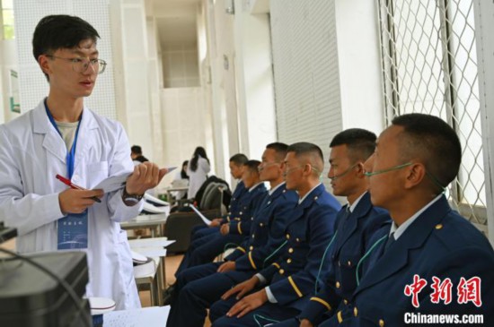 圖為研究團(tuán)隊成員登記消防員信息。　趙朗 攝