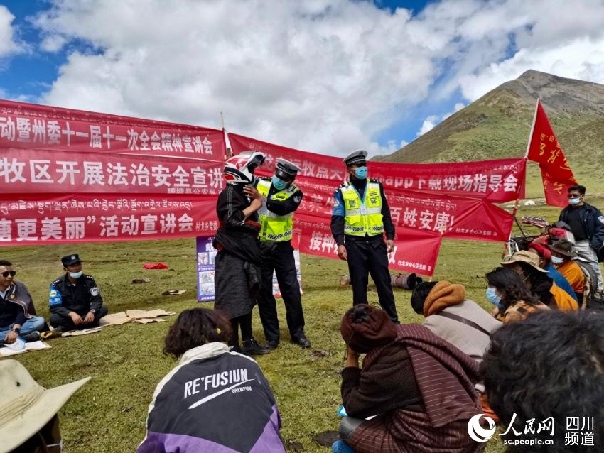 給牧民講如何佩戴安全頭盔。巴登攝