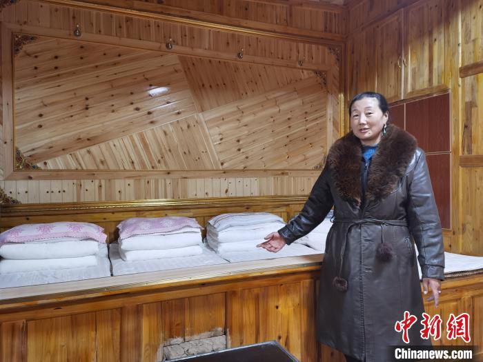 圖為德吉村村民鬧尖措介紹自家農(nóng)家樂?！∑钤鲚?攝
