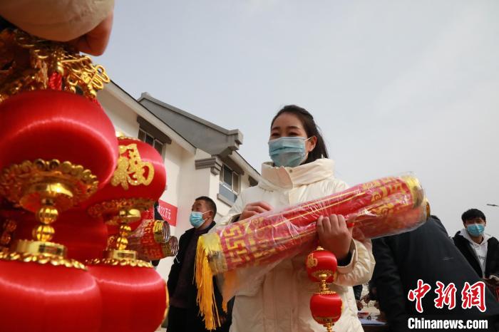 27日，蘭州新區(qū)為舟曲避險搬遷移民送“春節(jié)包”，楊周馬草前往領取，紅色寓意來年的日子紅紅火火?！∥航ㄜ?攝