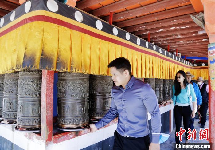 圖為外籍嘉賓體驗藏族傳統(tǒng)轉(zhuǎn)經(jīng)筒?！●R銘言 攝