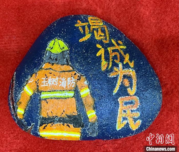 圖為玉樹(shù)消防指戰(zhàn)員創(chuàng)作的石頭畫(huà)作品《逆行在路上》。　孫瑞祥 攝