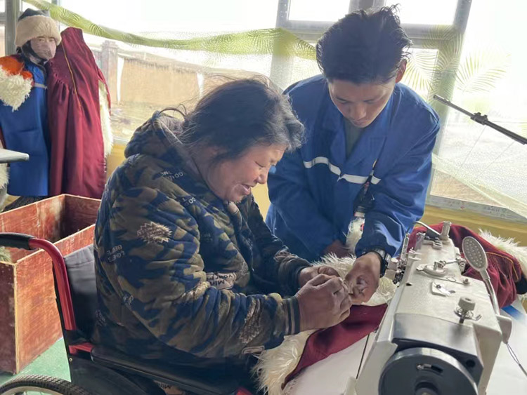 扎西奪爾登幫助殘疾員工裁剪。阿壩州文明辦供圖